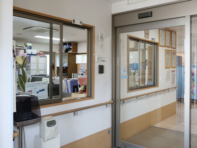 入口付近のフロント風景 玄関 広々として明るい入口は、訪れる方々を温かく迎え入れます。スタッフが常駐するカウンターがあり、快適な環境で皆様の日常を支援します。