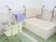 白とピンク、グリーンをベースにした清潔感あふれる個浴室。移動や立ち座りを補助する手すりが幾重にも設置されている。
