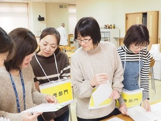 書類確認する職員の様子の会議室  