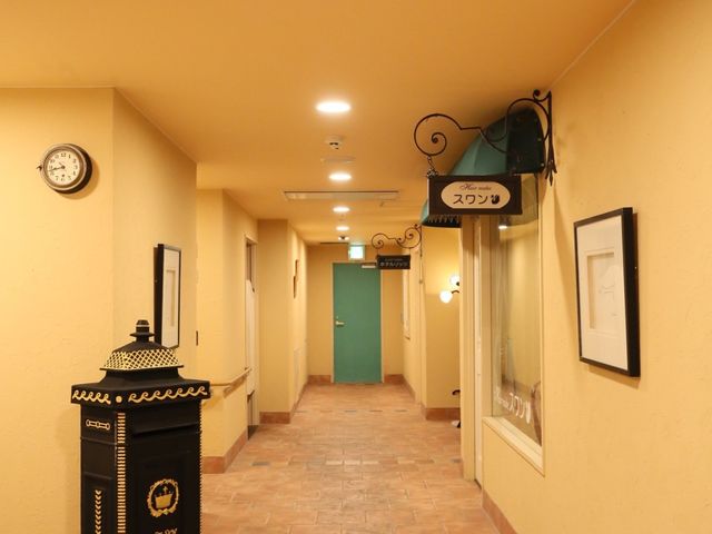 温かみのある廊下 廊下 ベージュの壁が温かな雰囲気を醸し出し、ゆったりとした廊下が安心感を与えます。壁の時計は日々のリズムを刻む上で便利です。