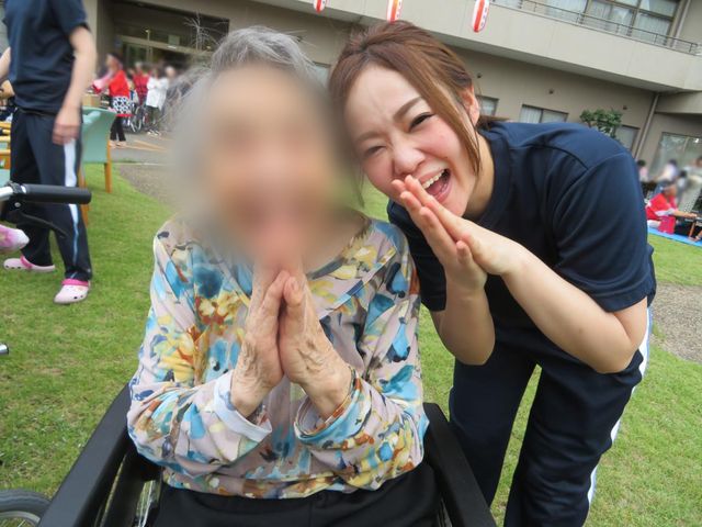 庭でのスタッフ交流 庭 利用者様とスタッフが笑顔で交流する場面。対話を通じて親密な関係構築が可能です。