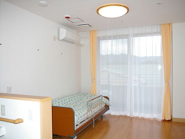 快適なベッドの居室 居室 自然光が降り注ぐ広々とした部屋で、快適に過ごせます。ベッドも備え付けられています。