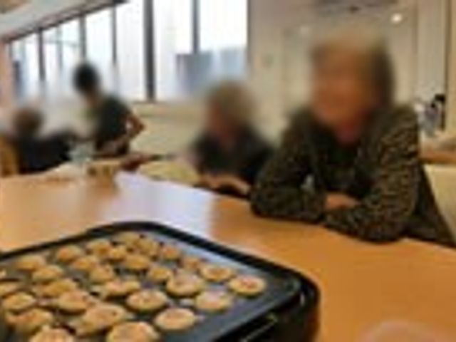 笑顔の集いの場 ダイニングルーム 自然光あふれる明るい場所では、参加者が楽しそうに会話しながら料理を囲んでいます。