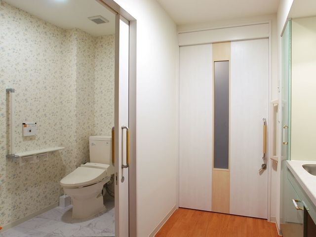 バリアフリーの洗面台とトイレ 個室2 安全な手すり付きの清潔なトイレは、ご利用者様の日々の生活を支える配慮が感じられます。
