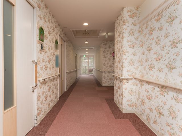 柔らかい光の廊下 通路 手すりが配された温かみのある壁紙の廊下です。通路も広く、安全に歩行できるよう工夫されています。