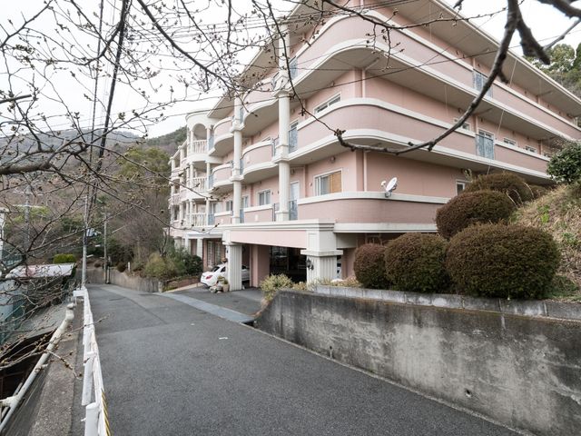 ピンク色の建物の外観 外観 丘の上に佇む、落ち着いた色合いの建物です。ゆったりとしたアプローチが印象的で、清潔感のある環境をお探しの方には理想的です。