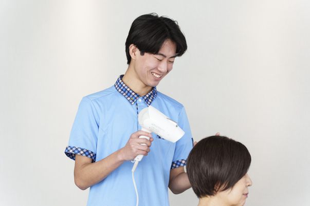 笑顔のスタッフが施術する理美容室