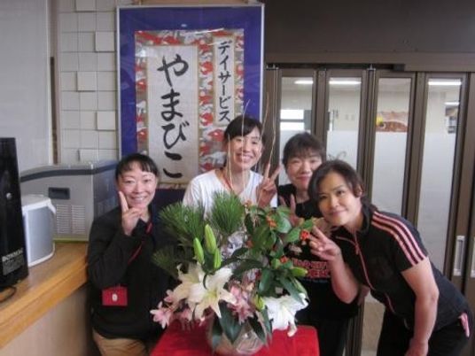 スタッフが花の前で笑うロビー  