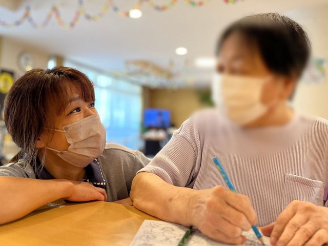 和やかなスタッフと利用者のシーン リビング 温かな雰囲気の中で交流が楽しめるスペースです。リラックスしながらアクティビティを共有できます。