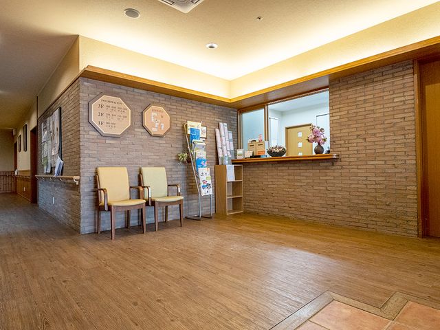 暖かな雰囲気の受付 フロント 暖かい色調のフロントは、利用者やスタッフの交流に適した快適な雰囲気を提供します。