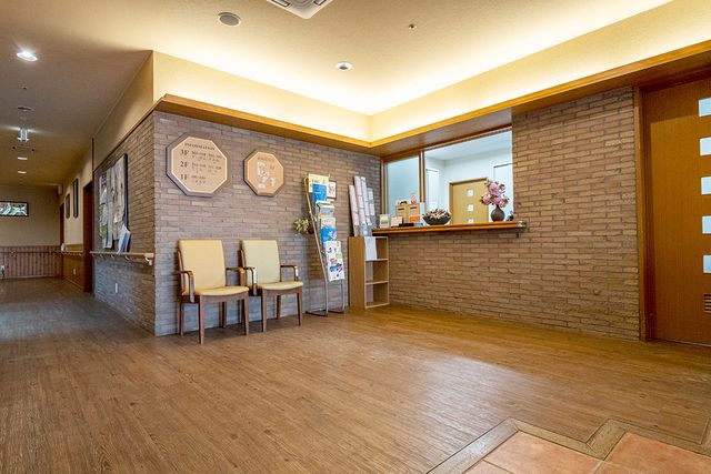 暖かな雰囲気の受付 フロント 暖かい色調のフロントは、利用者やスタッフの交流に適した快適な雰囲気を提供します。