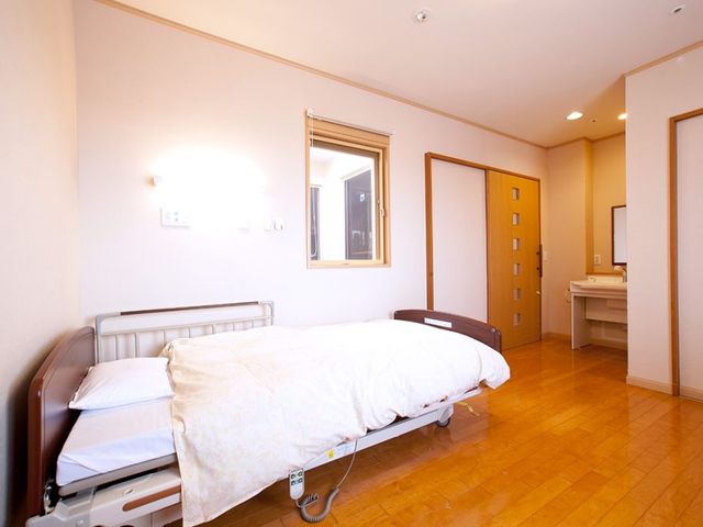 快適な雰囲気の居室 居室 温かみのある床材と明るい照明で、快適な雰囲気が広がっています。ベッド横には使いやすい洗面台も完備です。