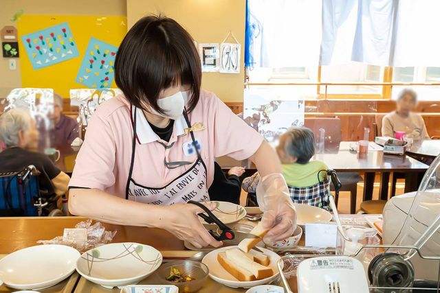 食事の準備風景 ダイニングルーム スタッフが利用者のために食事を丁寧に準備しています。自然光が心地良く差し込む空間です。