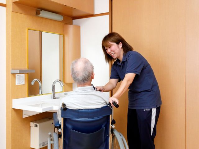 車椅子利用者との和やかな会話の様子 居室 車椅子を利用されている方とのコミュニケーションも大切にする、居住空間の一例です。