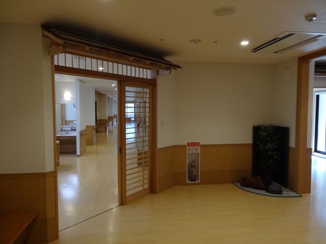 開放的な入口の廊下 廊下 広々とした廊下は、車椅子でも通りやすく開放感があります。柔らかな照明で落ち着ける空間です。
