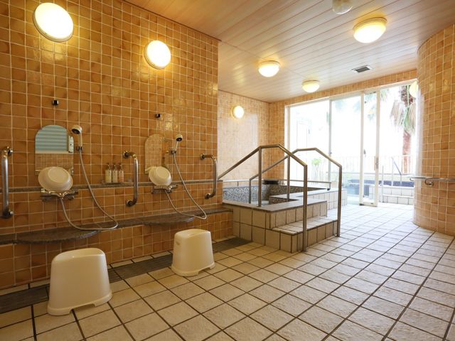 明るい浴室の内観 大浴場 手すり付きで安全を考えた設計の浴室です。採光を多く取り入れ、明るく清潔な雰囲気が保たれています。