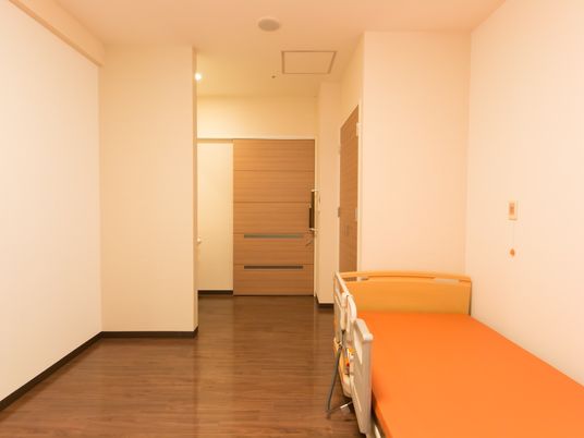 奥行きのある室内には、介護ベッドがある。入り口がスライド式ドアのため、車椅子のまま入室することができる。