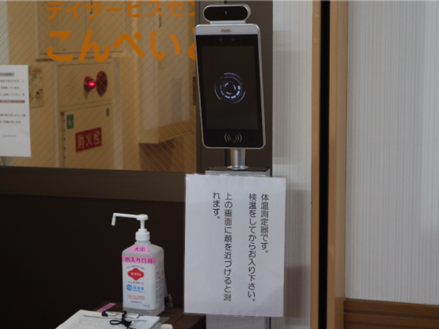 非接触検温機のあるロビー ロビー   非接触の検温機と手指消毒液が置かれたロビーです。入口での体調確認がしやすく、安心感のある受け入れ環境です。