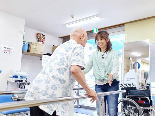 会話を楽しむスペース 機能訓練室 広々とした訓練室で、スタッフが優しく支援しています。安心してリハビリに取り組めます。