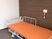 電動式のリクライニング介護ベッドが居室の一画に置かれている。ベッドには転落防止の柵などが備え付けられ、壁にナースコールも設置されている。