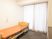 奥に大きな掃き出し窓があり、左の壁際にオレンジ色の介護用ベッド置かれている。ベッドの上方の壁にナースコールも取り付けられている。