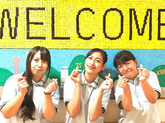 笑顔のスタッフと掲示物  