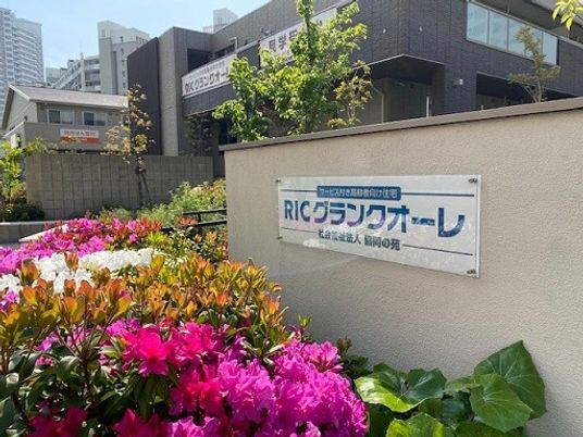 施設看板と植栽の外観  
