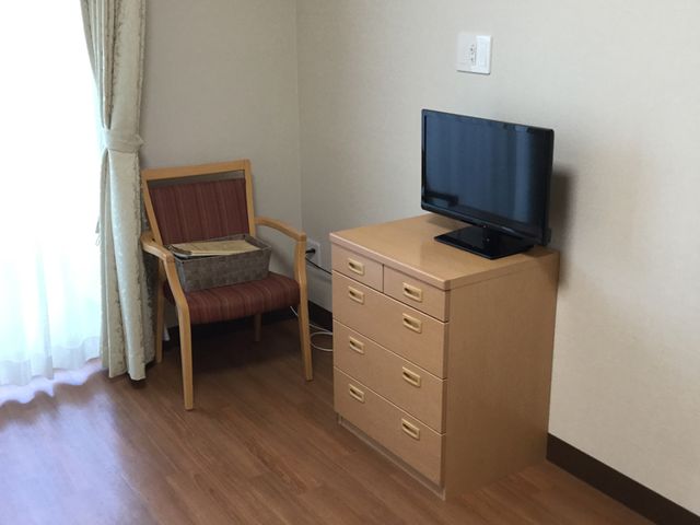 椅子とテレビのある部屋 居室 木製家具が配置された居室です。窓からの自然光で、明るく快適に過ごせます。