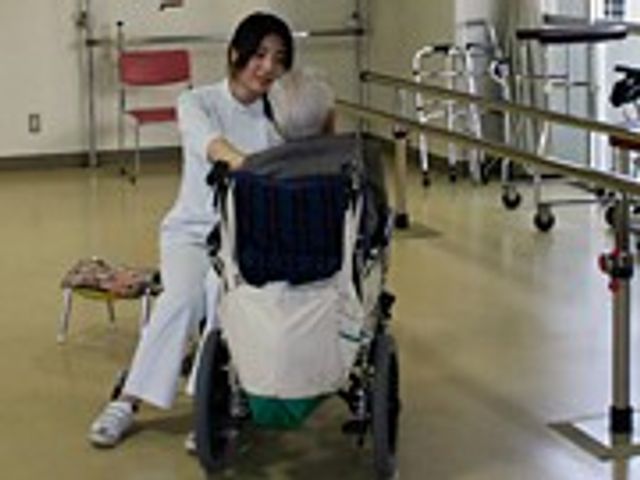 看護師と利用者の機能訓練室 機能訓練室 スタッフが明るい笑顔で、一人ひとりに合わせたサポートを提供している様子が伺えます。心地よい環境でのリハビリをご提供します。
