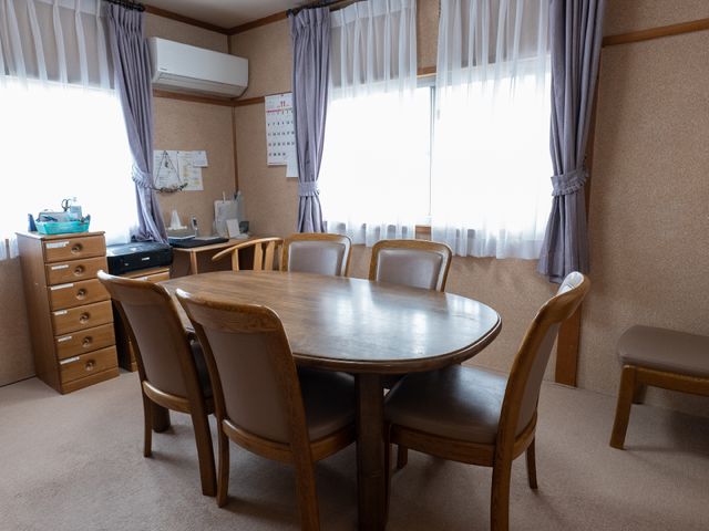 会議用テーブルのある部屋 共有スペース 窓から自然光が差し込む温かみのあるスペースで、チームミーティングやプログラム計画に適しています。