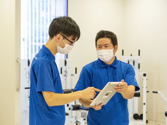 訓練機器を確認するスタッフ 機能訓練室  