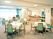 サムネイル 施設の写真 四人掛けのテーブルと椅子が並ぶ施設内の共有スペースの写真。食堂のようなスペース
