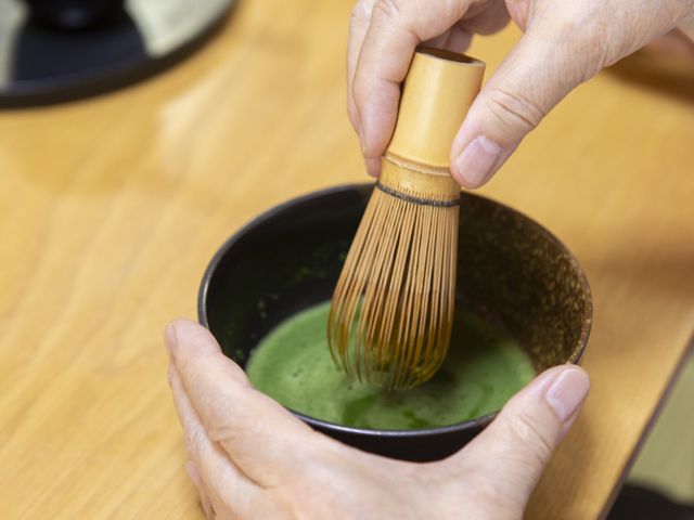 抹茶を点てる手元 多彩なアクティビティ 福祉施設での温かい交流の一場面です。抹茶を点てる手元が、心温まるひとときを演出しています。