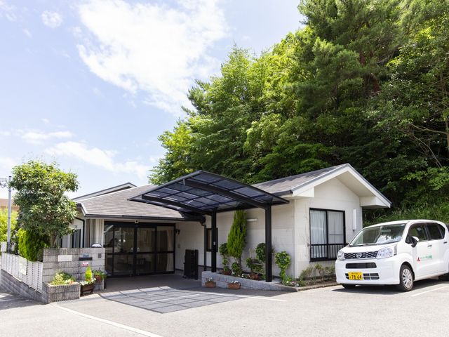 緑に囲まれた建物外観 外観 木々に囲まれた施設のエントランスでは、自然を感じながら落ち着いた雰囲気で働けます。
