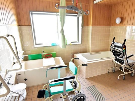 一人用の浴槽が二つ並べて設置され、中央にはカーテンを引くことができる。リフトやバスボードがあり、シャワーチェアも置かれている。
