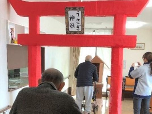 「うさぎ神社」と書かれた手作りの赤い鳥居の奥には社があり、お参りができるようになっている。2名の男性入居者が参っている。