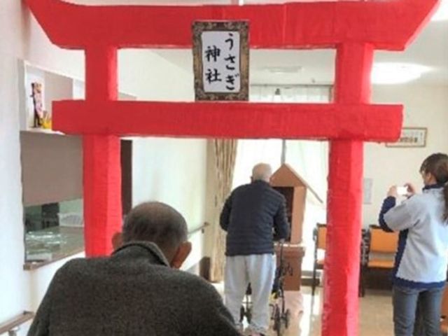 鳥居とリハビリ中の高齢者 初詣 赤い鳥居を背に、リハビリに取り組む姿が見られます。心身の活性化を図るため工夫された空間でしょう。