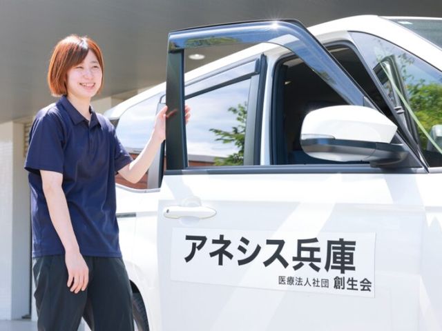 笑顔のスタッフと車両 外観 笑顔のスタッフが車両のそばに立ち、今日の準備をしています。温かい雰囲気が感じられます。