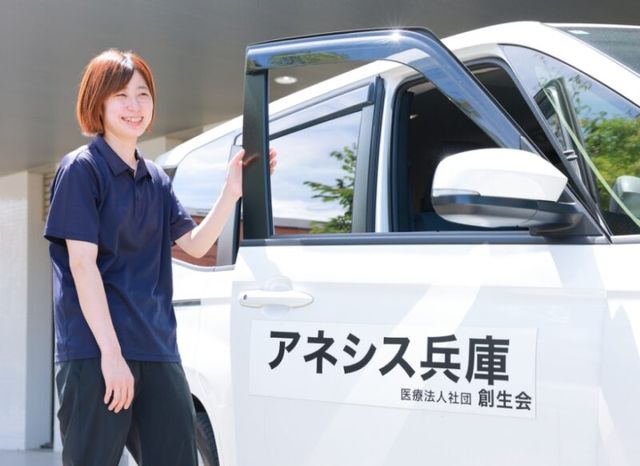 笑顔のスタッフと車両 外観 笑顔のスタッフが車両のそばに立ち、今日の準備をしています。温かい雰囲気が感じられます。