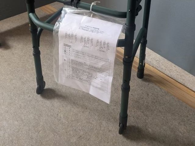歩行器と書類のある廊下 廊下   歩行器のそばに書類が掛けられており、通路の様子がわかります。移動を支える備えが見えるため、働く環境の確認にも役立ちます。