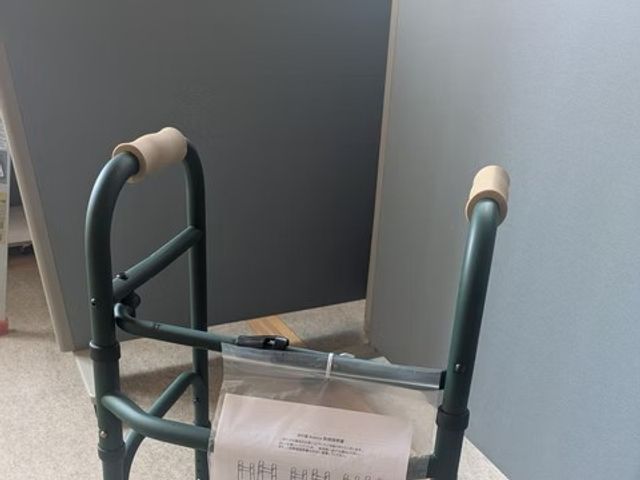 歩行補助器のある廊下 廊下   手すり付きの歩行補助器が置かれた、落ち着いた色合いの通路です。移動を支える備えが見え、働く環境の配慮を感じられます。