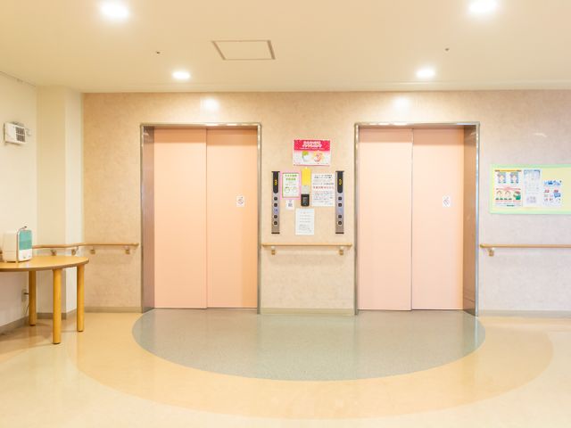清潔感あるエレベーターホール エレベーターホール この施設は、明るく清潔なエレベーターホールがご利用いただけます。手すりが整っており、安全に配慮された移動空間です。