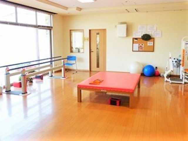 訓練用具のある部屋 リハビリスペース 広々とした機能訓練室は、明るい日差しが差し込む快適な環境です。様々なリハビリ機器を使って、日常生活の向上を目指せます。