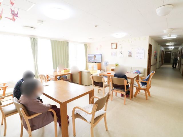共有スペースの様子 共有スペース 窓辺の日差しに照らされたダイニングで、ゆったりと過ごす方々の姿。お話しながら、快適な時間をお過ごしいただけます。