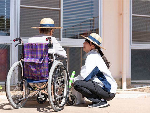 外で談笑する人々 庭 中庭で交流を楽しむ様子です。リラックスした雰囲気が感じられ、穏やかな時間を過ごせます。