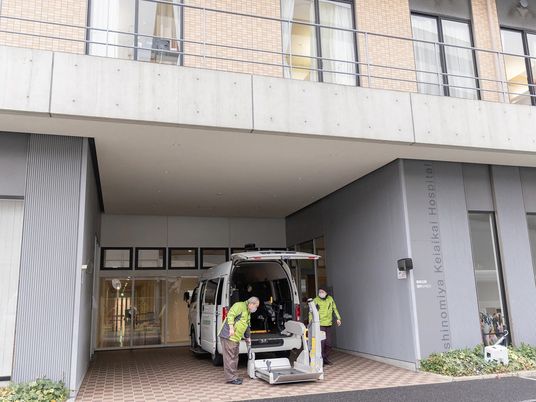 送迎車と職員がいる玄関  