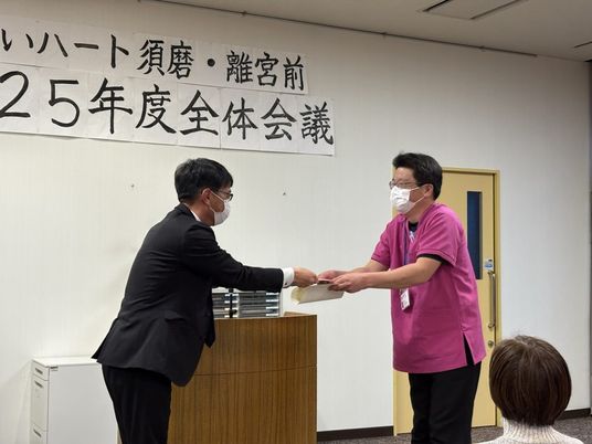 会議で書類を受け渡す室内  