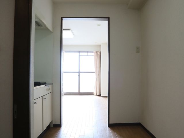 明るい室内の角部屋 居室 広々とした角部屋は自然光がたっぷりと差し込み、快適な生活空間を提供しています。壁面の木目調が温かみのある雰囲気を演出しています。