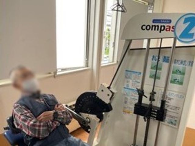 リハビリ設備のある室内 機能訓練室 明るい室内で、リハビリ用機器が完備されています。利用者の方がリラックスして訓練に励んでいます。
