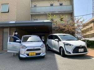 送迎車と職員の外観  